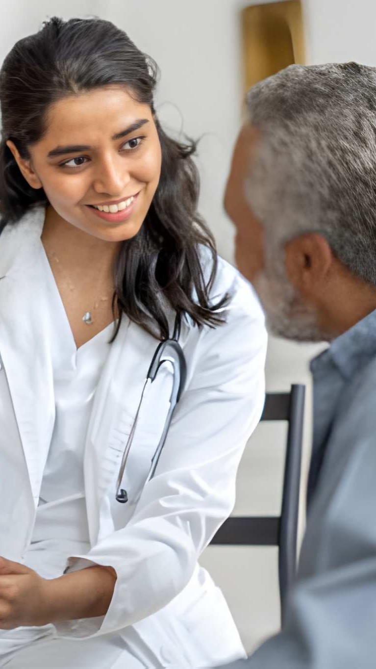 Smiling doctor talking with an older man